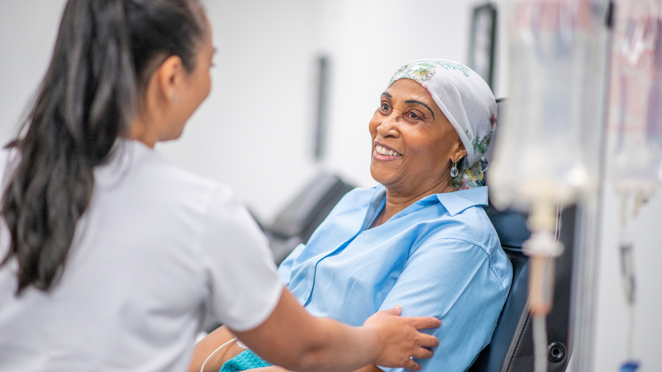 Nurse helping older woman undergoing cancer treatment
